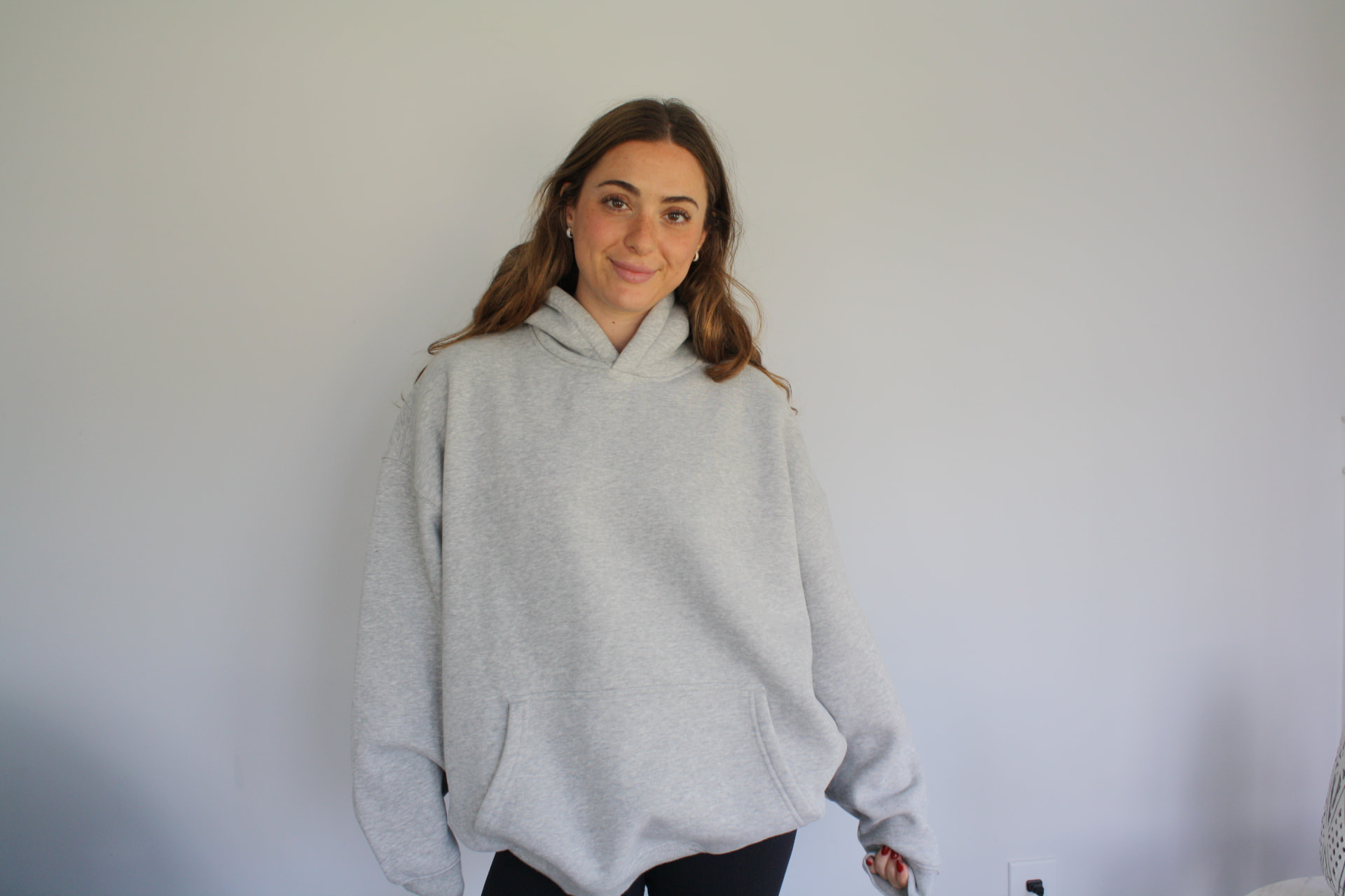 Model wearing the DMK Studios Essential Hoodie in grey